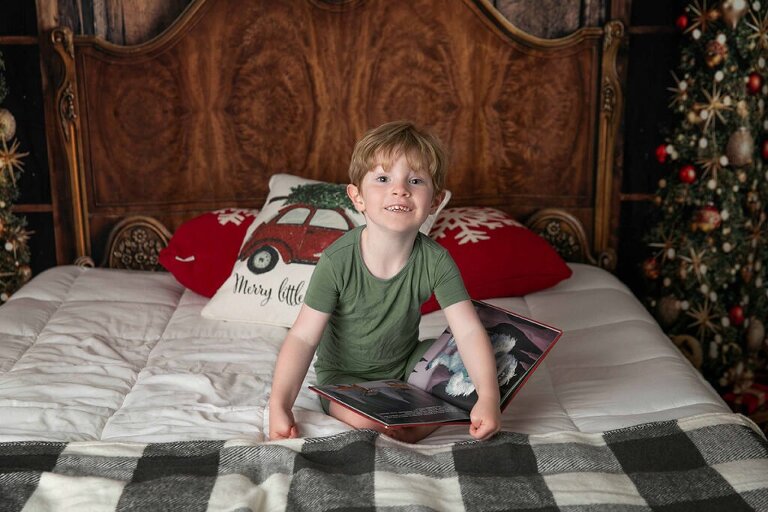 little boy in green pjs reading Rudolph 