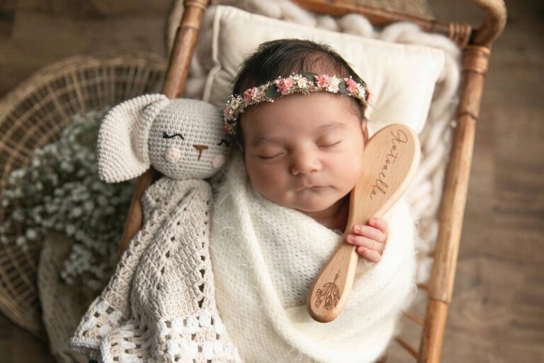 baby holding keepsake brush with her name on it during beaufort newborn session