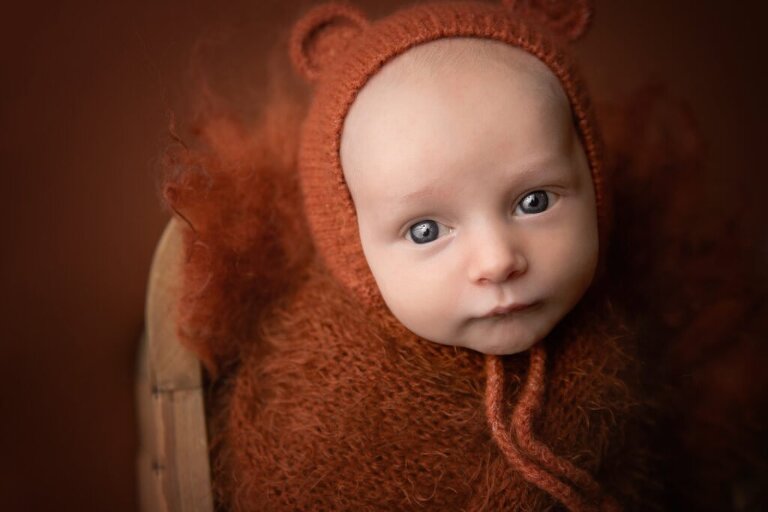 bright eyed newborn in rust orange