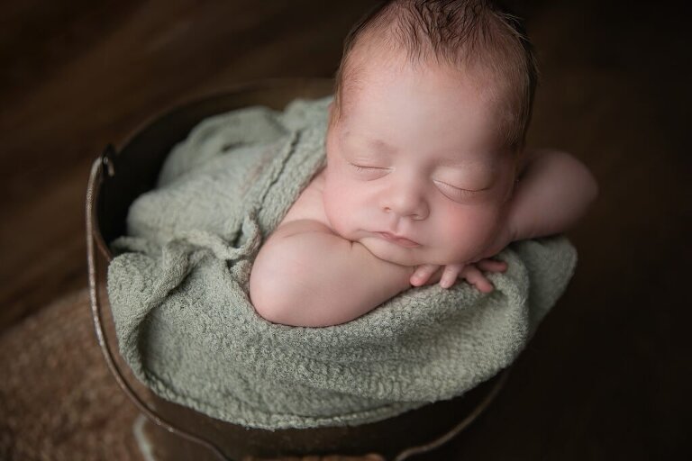 Baby boy in green bucket pose