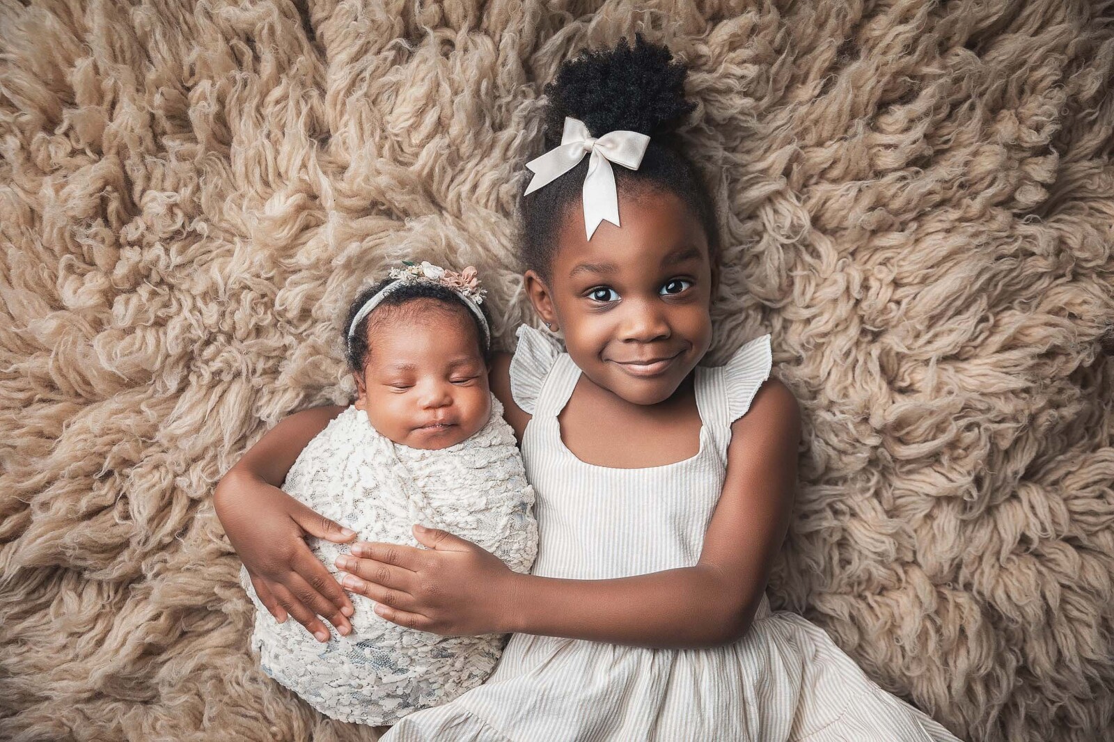 African American baby girl with her big sister in neutral colors